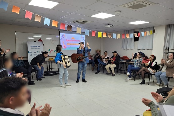 Voluntários tocam instrumentos no encerramento da oficina.