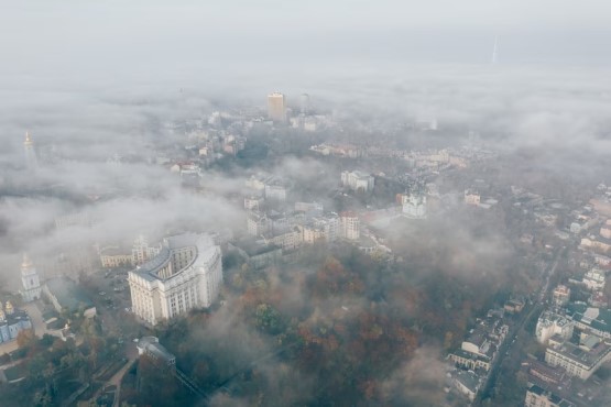 Vista aérea de cidade coberta de fumaça.
