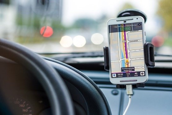 Celular em apoio de carro mostrando caminho no GPS.