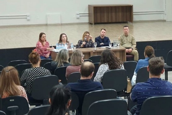 Autoridades sentados de frente para o público.