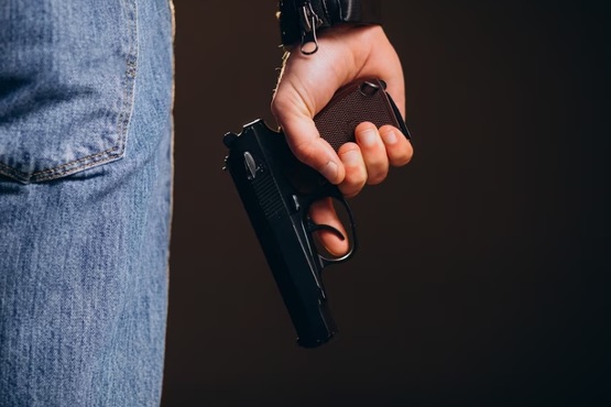 Pessoa segurando arma.