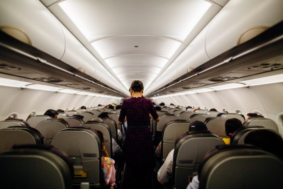 Homem no corredor de avião.