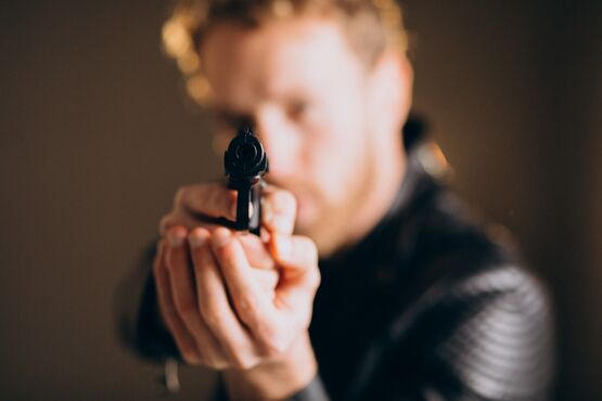 Homem apontando arma.