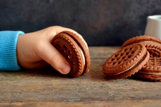 Mãe de criança segurando biscoito.