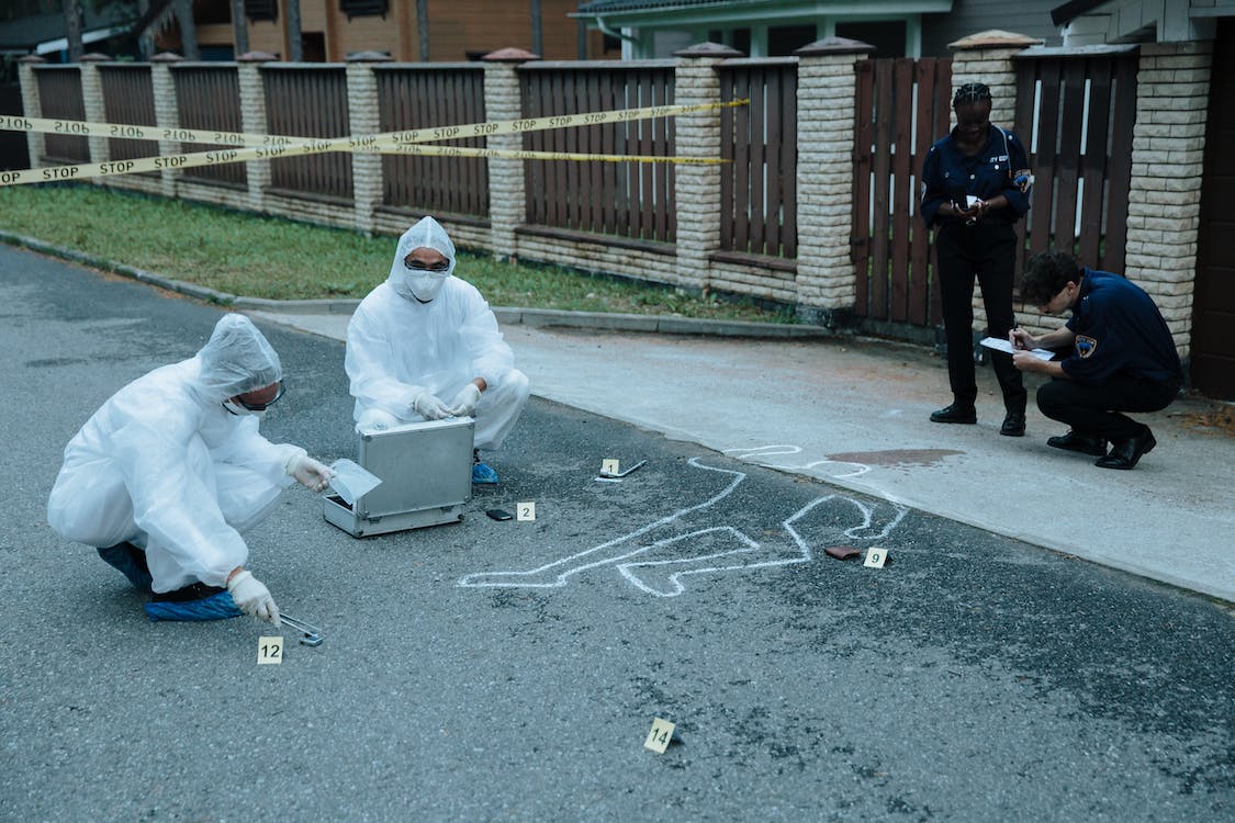 Peritos analisando local de crime.
