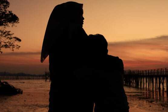 Mulher abraçando criança.