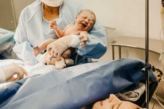 Recém nascido no colo de médica.