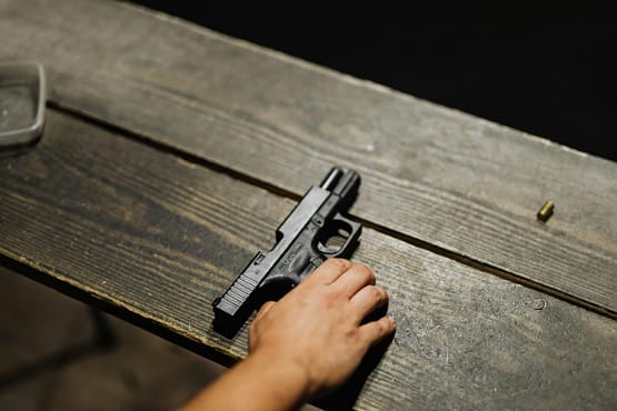 Mão segurando arma.