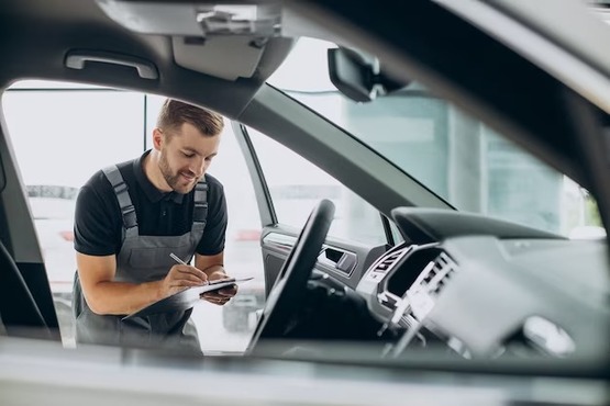 Homem fazendo vistoria em carro.