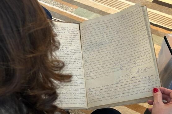 mulher lendo caderno escrito