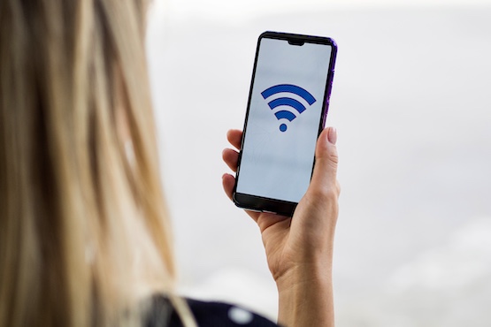 mulher olhando tela de celular que mostra sinal de internet