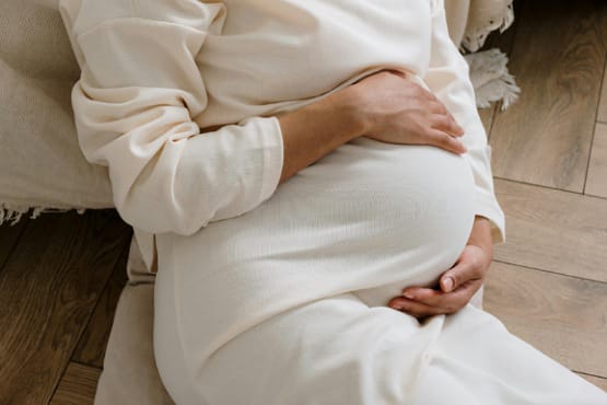 mulher grávida com as mãos na barriga