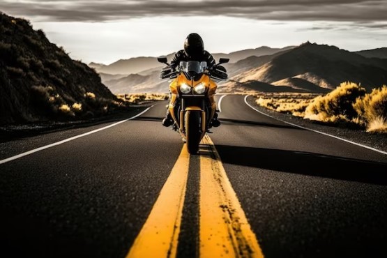 Homem em moto amarela na estrada