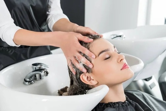 mulher lavando cabelo em salão de beleza