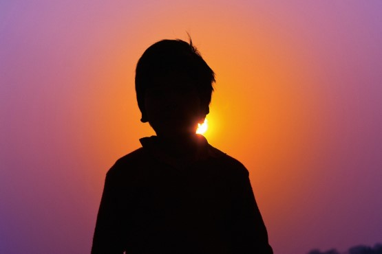 Sombra de criança com sol atrás