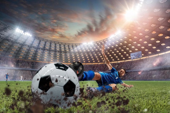 Jogador chutando bota de futebol no meio de um estádio lotado