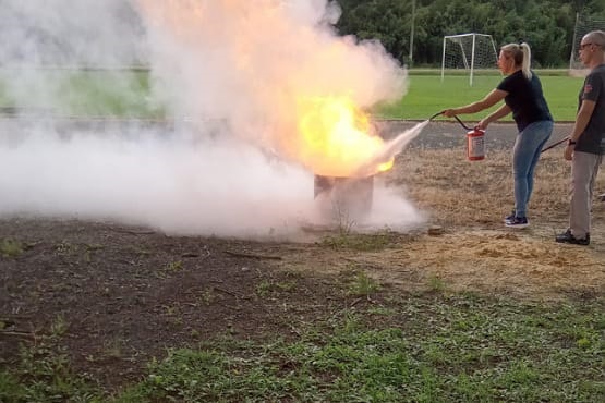 Mulher apagando incêndio em curso de acidente no trabalho