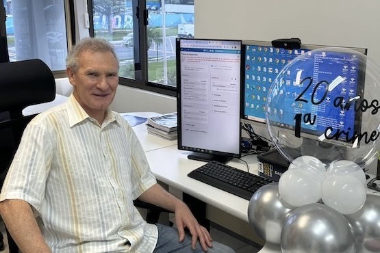 Homem sentado em frente ao computador com balão de comemoração ao lado direito