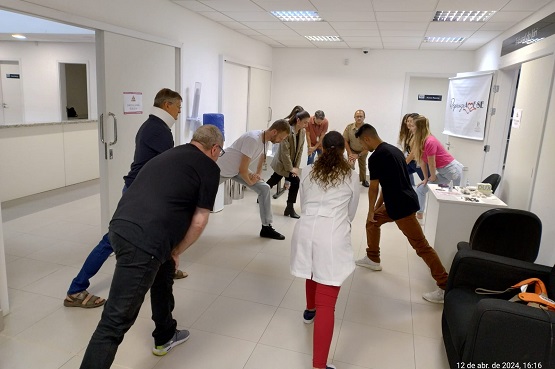 11 pessoas, dentre elas homens e mulheres, servidores do TJSC e membros do programa Saúde Itinerante, em círculo realizam exercícios para o alongamento das pernas