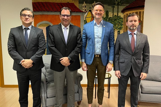 Foto de quatro homens, em pé de terno e gravata..