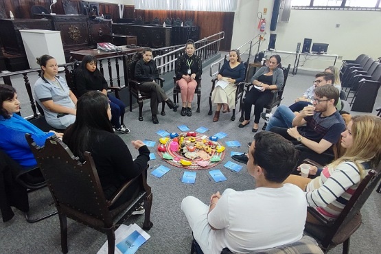 Mulheres e homens sentados em círculo.