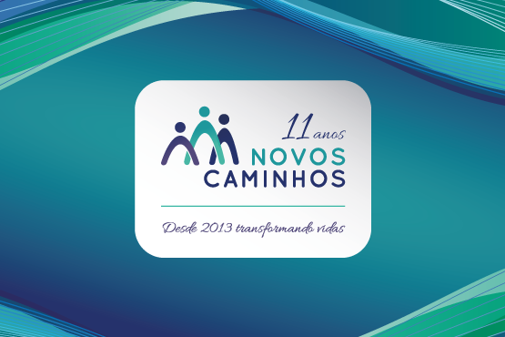 A imagem é um banner comemorativo de 11 anos de uma iniciativa chamada "Novos Caminhos". No centro, há um logotipo que consiste em três figuras estilizadas que parecem representar pessoas, com a figura central em verde e as duas laterais em azul. Acima do logotipo, está escrito "11 anos" e abaixo "NOVOS CAMINHOS". Na parte inferior, há a frase "Desde 2013 transformando vidas". O fundo do banner é em tons de azul e verde, com linhas onduladas que criam um efeito dinâmico. (ft 1)