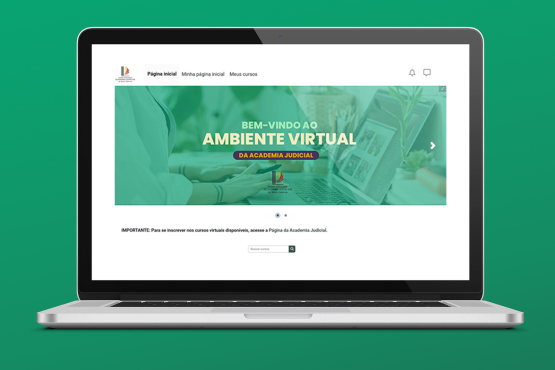 A imagem mostra a tela de um laptop exibindo uma página da web. No topo da página, há um logotipo no canto esquerdo, seguido por um menu com as opções "Página inicial", "Minha página inicial" e "Meus cursos". Abaixo, há uma imagem em destaque com um fundo verde e o texto "BEM-VINDO AO AMBIENTE VIRTUAL DA ACADEMIA JUDICIAL". Logo abaixo da imagem, há um aviso em texto que diz: "IMPORTANTE: Para se inscrever nos cursos virtuais disponíveis, acesse a Página da Academia Judicial." O fundo da imagem é verde.