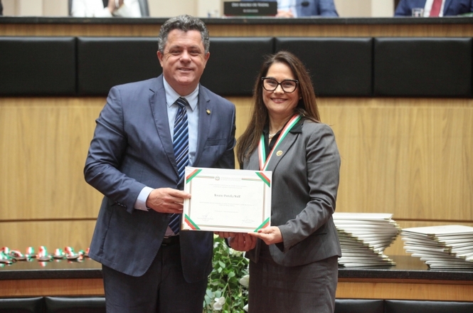 A imagem mostra dois magistrados, um deles é a desembargadora Rosane Portella Wolff, e o ministro Marco Aurélio Gastaldi Buzzi. Ambos sorriem para a foto enquanto seguram juntos um certificado.