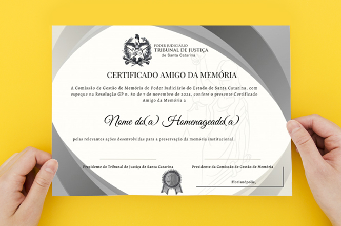 A imagem mostra um certificado com o título "Certificado Amigo da Memória" emitido pelo Tribunal de Justiça de Santa Catarina. O fundo amarelo destaca o certificado, que é segurado por duas mãos.