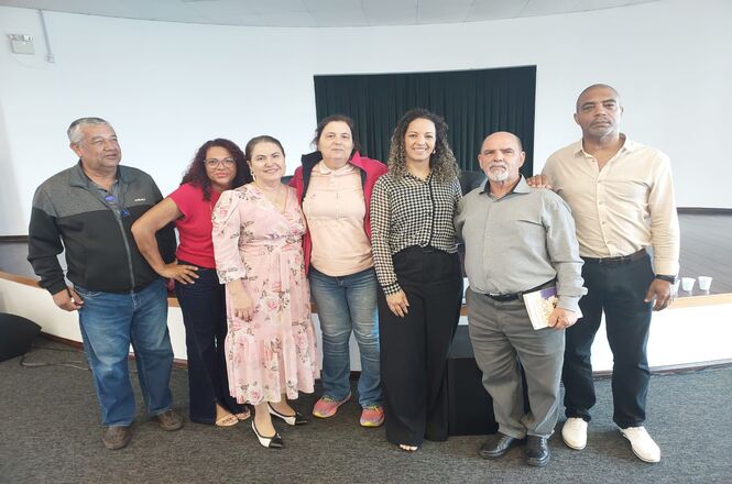 A imagem mostra um grupo de sete conselheiros tutelares posando juntos para a foto na palestra da desembargadora Hildemar Meneguzzi de Carvalho. Eles estão de pé, lado a lado, sorrindo para a câmera.