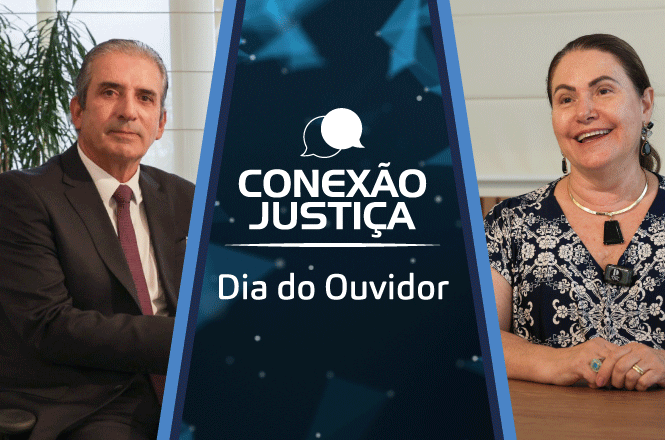 Duas pessoas estão sentadas em uma mesa, uma ao lado da outra, mas separadas por uma faixa central. À esquerda, um homem de terno escuro e gravata vermelha está sentado, com uma expressão séria. À direita, uma mulher com cabelo preso e vestindo uma blusa estampada sorri. Entre eles, há uma faixa azul com o texto "CONEXÃO JUSTIÇA" e "Dia do Ouvidor" em destaque. Ao fundo, há uma planta e uma parede clara.