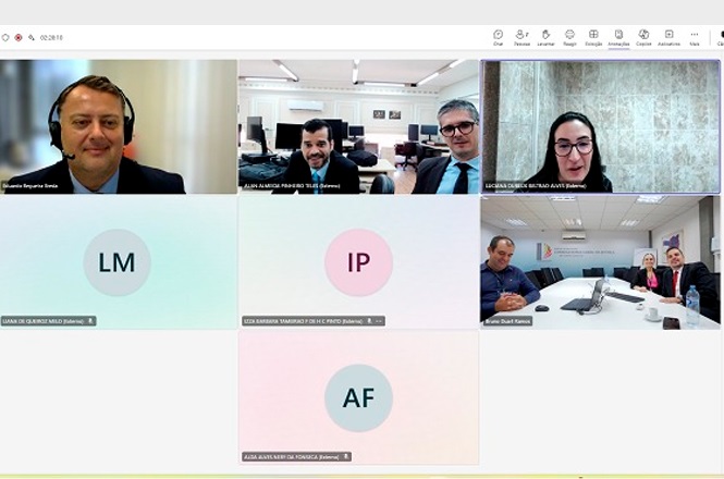 Tela de uma videoconferência com várias pessoas participando. No canto superior esquerdo, há um homem de terno e fone de ouvido. Ao lado, três homens estão juntos em um escritório, todos de terno. No canto superior direito, uma mulher com óculos está em uma sala com parede de mármore. Abaixo, há três círculos com iniciais: LM, IP e AF, indicando participantes sem vídeo. No canto inferior direito, três pessoas estão em uma sala de reuniões, duas delas de terno e uma de camisa azul. No lado direito da tela, há uma seção com "Anotações da reunião" e "Tarefas de acompanhamento".