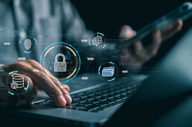 A imagem mostra uma pessoa utilizando um laptop e um smartphone. Em frente ao laptop, há ícones digitais flutuantes relacionados à segurança cibernética, como um cadeado, uma impressão digital, um globo, um banco de dados e uma pasta de arquivos. Esses ícones representam conceitos de proteção de dados e segurança da informação. O ambiente parece moderno, sugirindo um foco em tecnologia e segurança digital.
