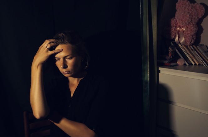 Na imagem, há uma pessoa sentada em um ambiente escuro, lendo um livro. A iluminação vem de três velas acesas colocadas sobre uma mesa à sua frente. A luz das velas cria um ambiente aconchegante e intimista, destacando a concentração da pessoa na leitura. A cena transmite uma sensação de tranquilidade e foco.