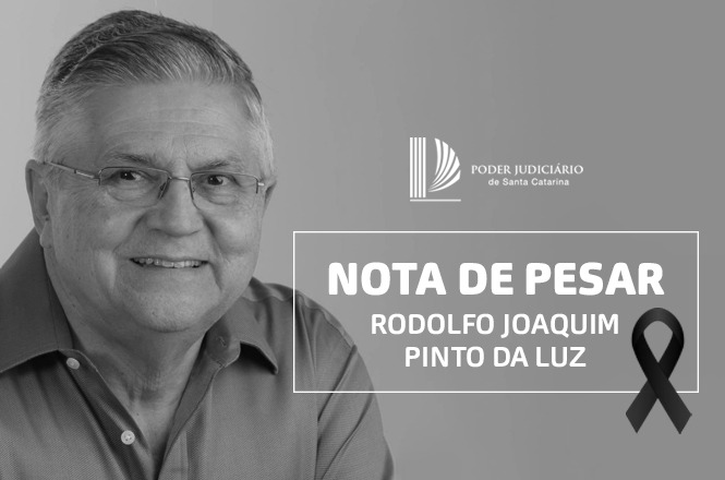 A imagem é uma nota de pesar do Poder Judiciário de Santa Catarina. No lado esquerdo, há a foto de um homem sorridente, usando óculos e uma camisa de botão. No lado direito, há um texto com as palavras "NOTA DE PESAR" seguido pelo nome "RODOLFO JOAQUIM PINTO DA LUZ". Há também um laço preto como símbolo de luto.