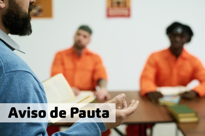 Uma imagem de pessoas em uma sala de aula ou reunião, provavelmente um grupo de presos recebendo instrução ou aconselhamento.