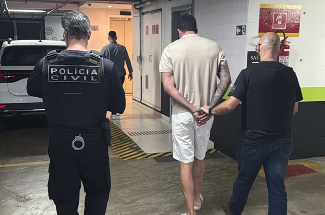 Foto colorida: policiais escoltam pessoa algemada em garagem, ação policial, conduzindo detido Forneça seus comentários sobre o BizChat