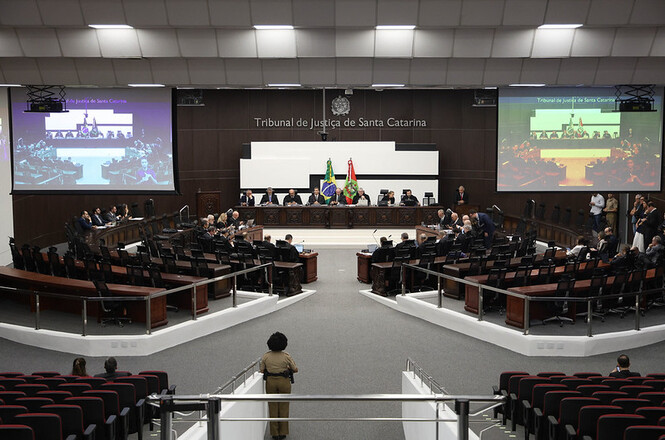Foto colorida: desembargadores à mesa no plenário do TJSC, ambiente institucional interno, sessão judicial, deliberando processos