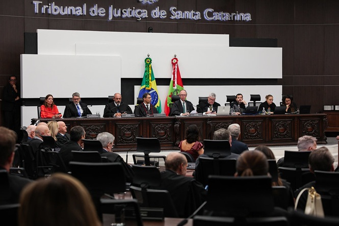 Foto colorida: Ao centro, O Excelentíssimo Presidente do TJSC, Rubens Schulz acompanhado de desembargadores à mesa no plenário em ambiente institucional interno