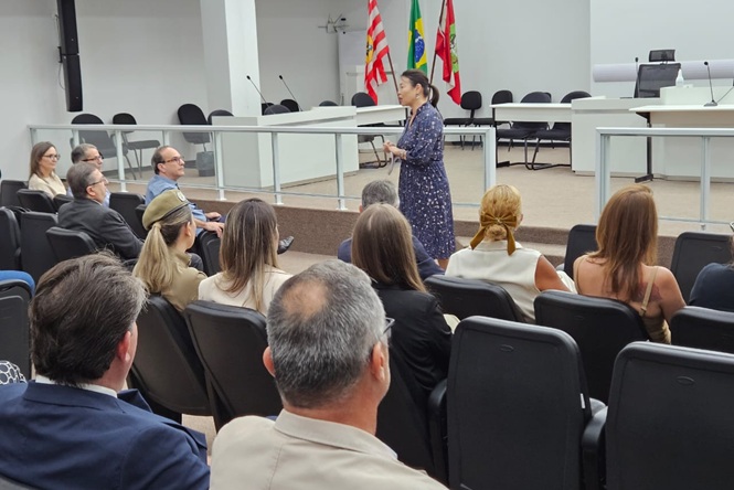 Foto colorida: palestrante diante do público, plenário judicial interno, ação de enfrentamento à violência doméstica , orientando participantes