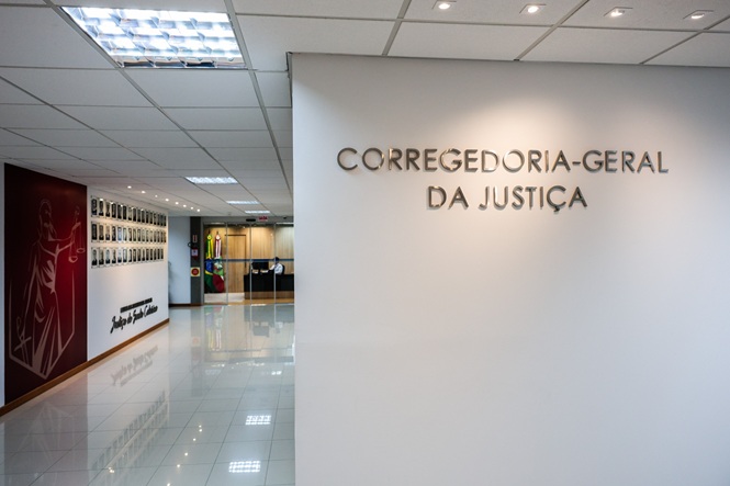 Foto horizontal: corredor da Corregedoria-Geral da Justiça do TJSC, com paredes brancas e iluminação institucional
