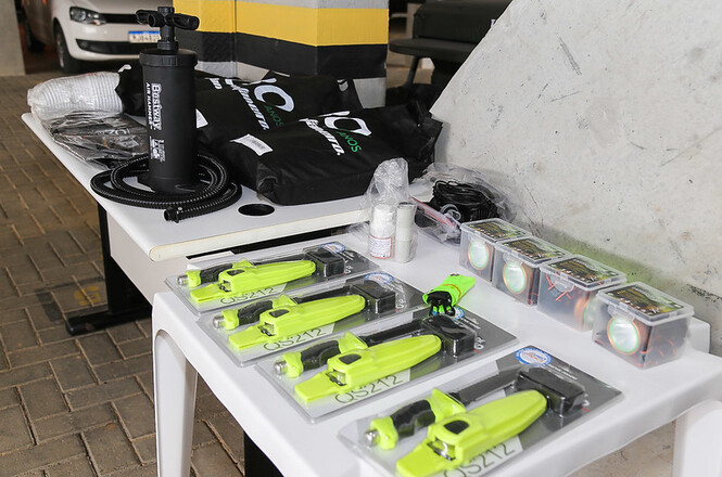 Foto kits amarelos e pretos sobre mesa branca, garagem ao fundo, utilitário, organizados para uso