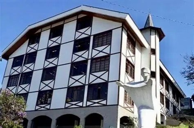 Foto horizontal: fachada da comarca de Brusque, prédio com arquitetura enxaimel e escultura em destaque, ambiente externo, clima institucional.