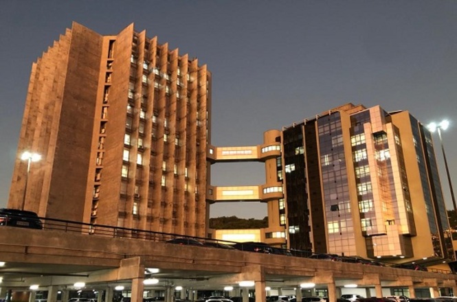 Foto horizontal: prédio do Tribunal de Justiça de Santa Catarina iluminado à noite, arquitetura em destaque, clima institucional e solene.