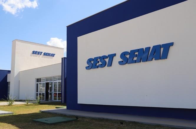 Foto horizontal: fachada do SEST SENAT, prédio institucional com identidade visual em destaque, clima de capacitação e serviços ao trabalhador.