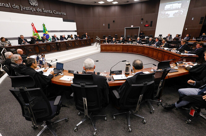 Foto horizontal: desembargadores participam de sessão do Órgão Especial do TJSC em plenário com mesa circular e autoridades ao redor.