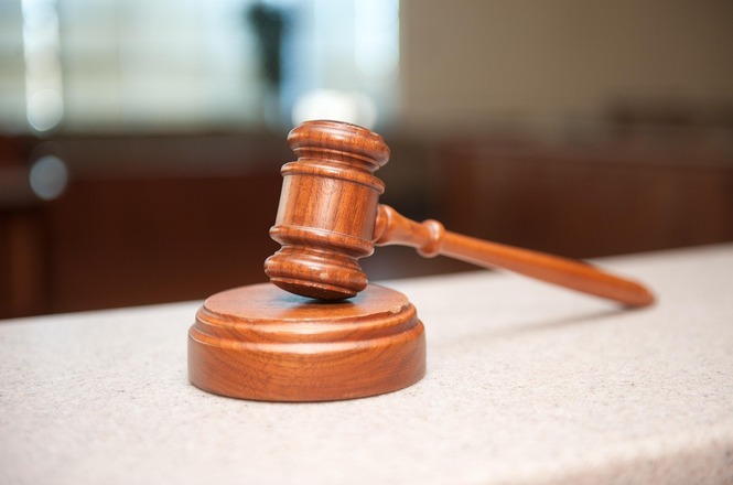 Foto ilustrativa: martelo judicial de madeira sobre bancada, símbolo da Justiça, das decisões judiciais e da atividade jurisdicional.