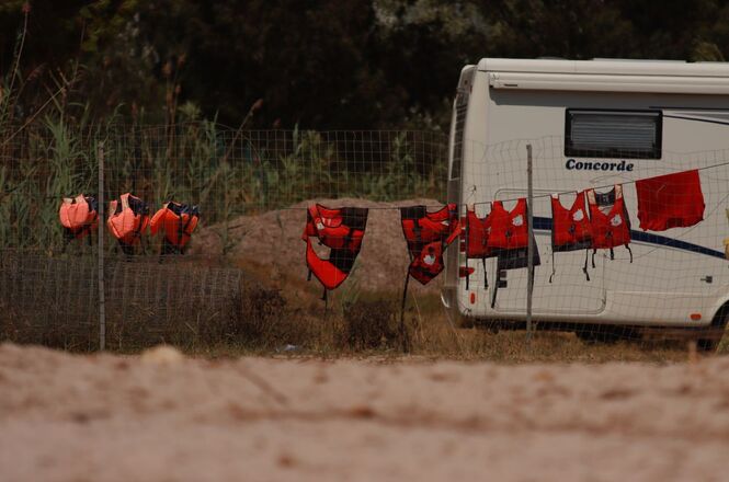 Foto ilustrativa: coletes salva-vidas secam em varal ao lado de motorhome, remetendo a operações de resgate e atendimento em situações de emergência.