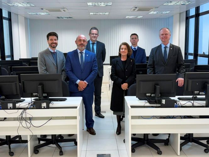 Foto horizontal: os desembargadores André Luiz Dacol, Vera Lúcia Ferreira Copetti e Rubens Schulz aparecem em primeiro plano durante visita institucional à Academia Judicial, acompanhados por magistrados e servidores.