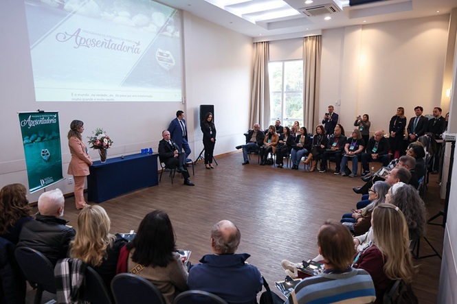 Foto horizontal: magistrados, servidores, familiares e convidados acompanham solenidade em homenagem à aposentadoria de integrante do Poder Judiciário, realizada em auditório institucional.
